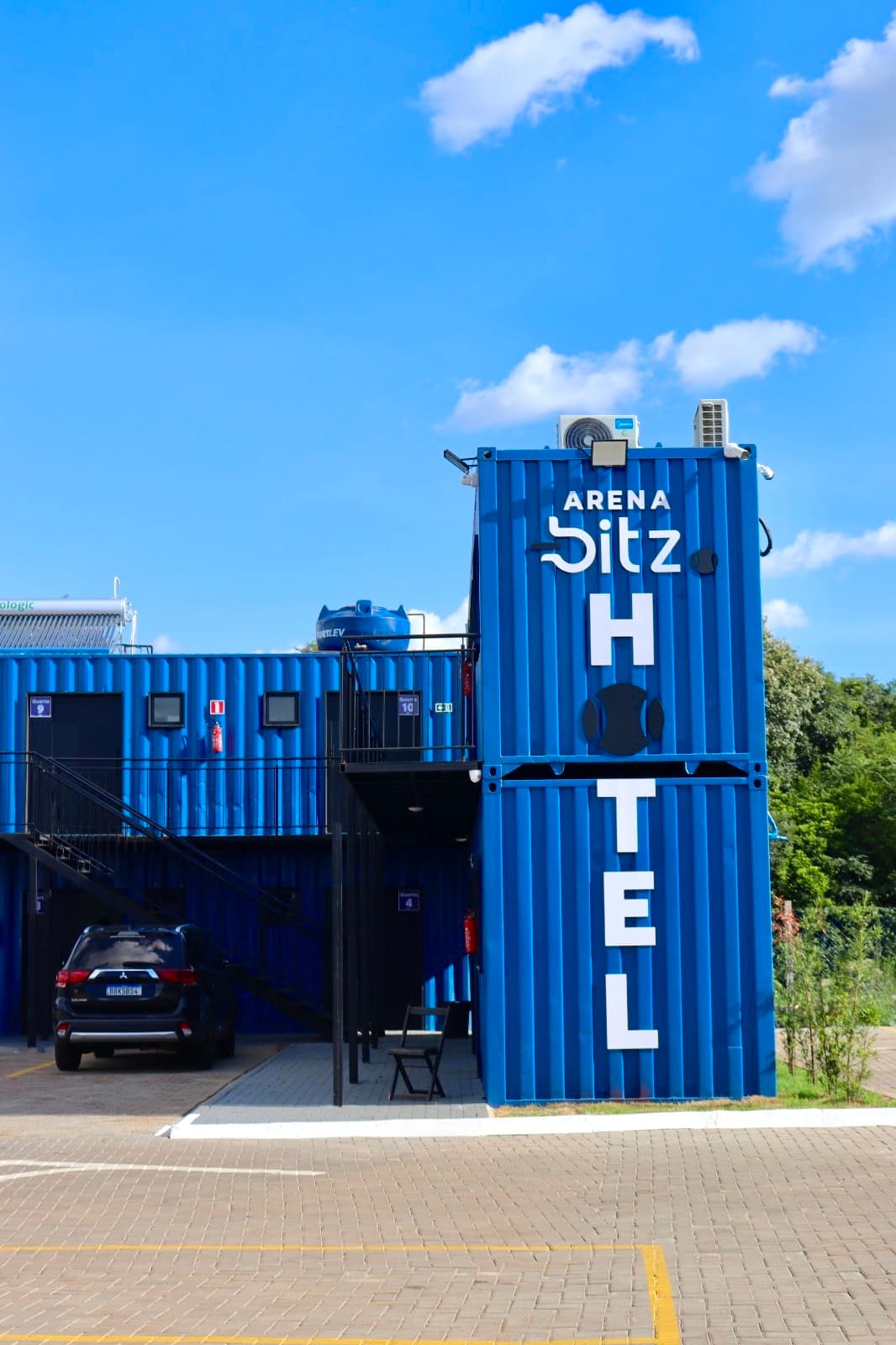 Fachada do Hotel Arena Bitz — prédio modular de contêineres com a placa Arena Bitz Hotel